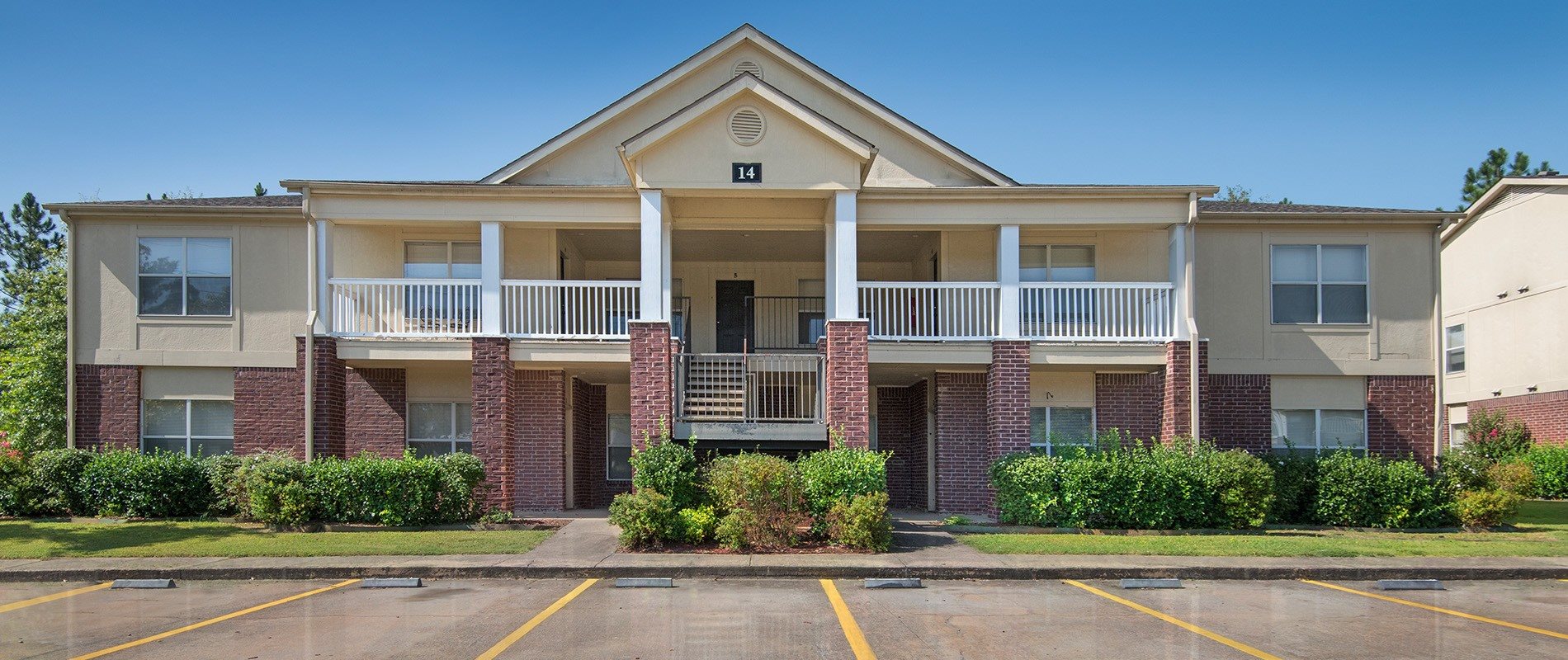 A two-story apartment building with a balcony on the second floor.